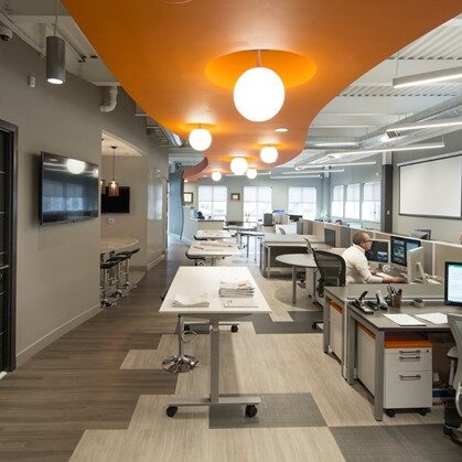 Interior of an office space with an orange ceiling panel and round light bulbs